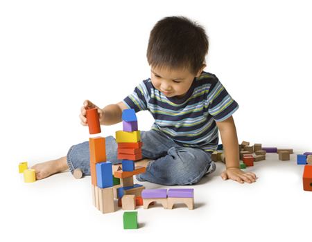 Child building tower with blocks.