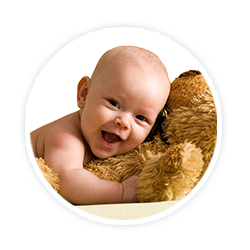 smiling baby lying on teddy bear