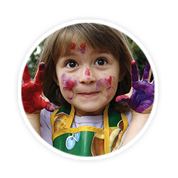 little girl with paint all over her face and hands